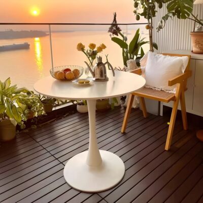 Modern round dining table with a sleek tulip base, set for a meal.