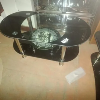 A stylish glass-topped coffee table with a sleek tempered glass surface and a sturdy base, adding elegance and modern appeal to any living space.