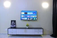 Lavish White Lumber TV Stand with a sleek and modern design, offering ample storage for electronics and media.