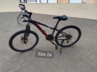 Durable mountain bike designed for off-road trails with knobby tires, suspension, and a sturdy frame.