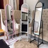 A free-standing, full-length cheval mirror with a swiveling frame, designed for adjustable viewing and elegant room decor.