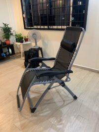 Foldable Full Recliner Lawn Chair in a reclining position on a grassy outdoor surface with adjustable armrests and cup holder.
