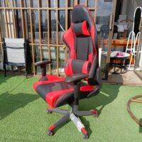 Ergonomic red and black gaming chair with lumbar support and adjustable features for enhanced comfort during long gaming sessions.