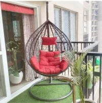 Colorful outdoor hammock swing hanging between two trees, perfect for relaxation in a garden or patio.